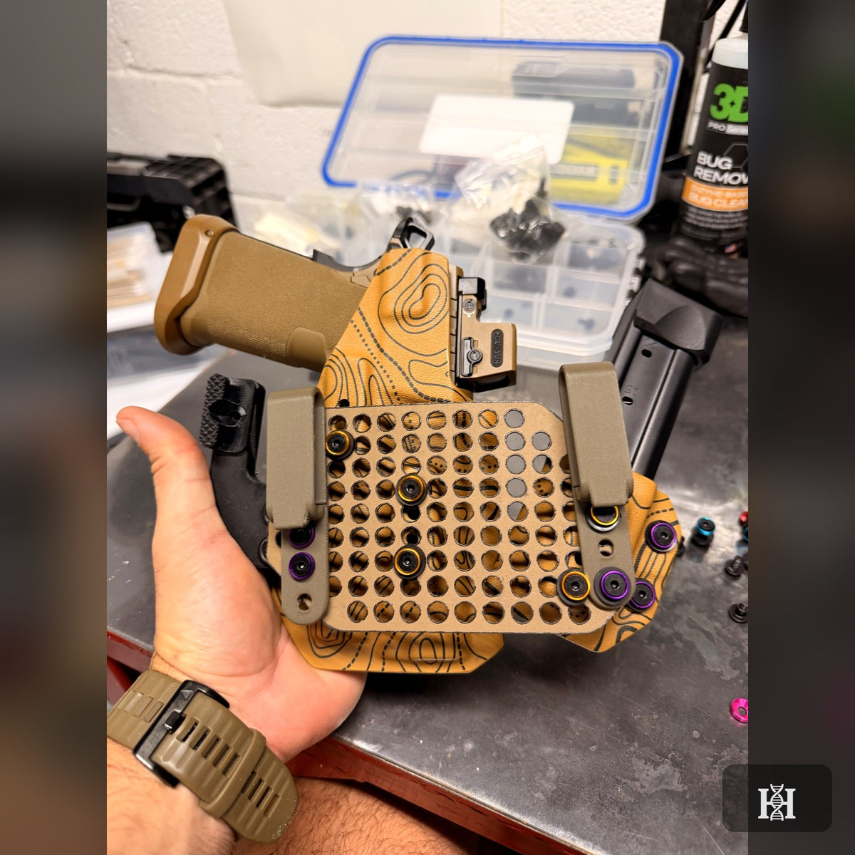Hand holding tan topo-print sidecar rig, back view