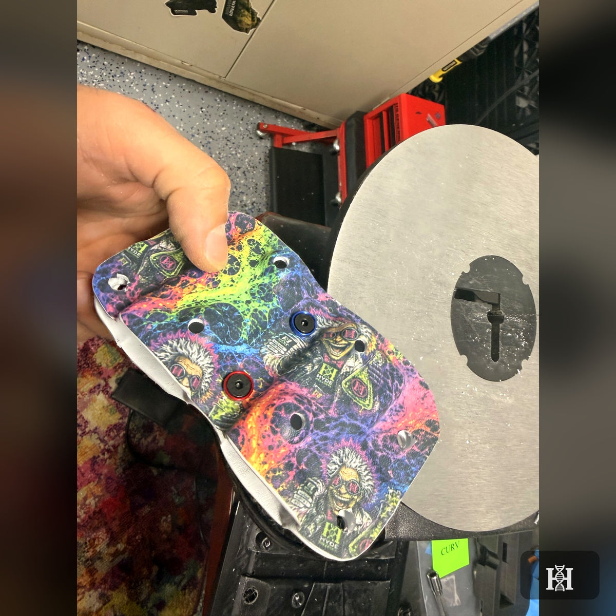 Unfinished mad-scientist-print OWB Kydex shell held in workshop